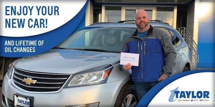 A person standing in front of their car, sharing a moment of pure joy and excitement.